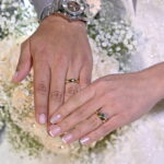 Pareja de novios con argollas de matrimonio en oro 18k y anillo de esmeralda