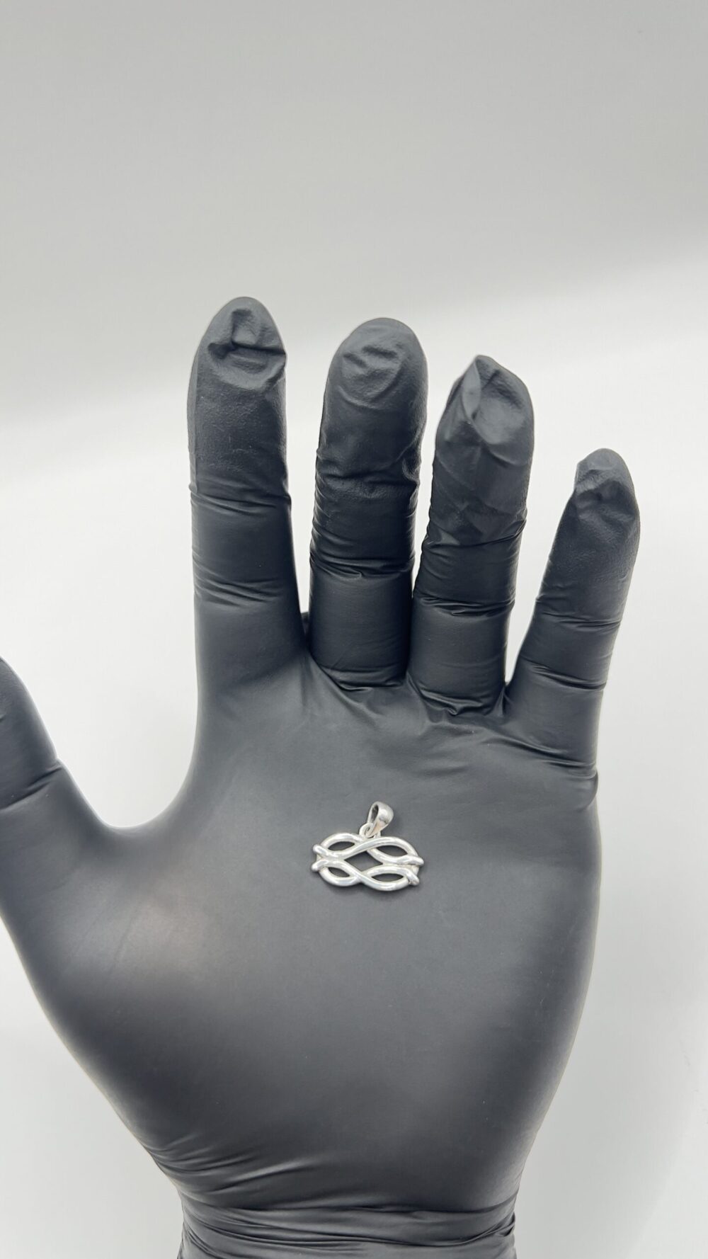 Dije de plata 925 con diseno de infinito doble sobre la mano