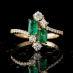 Anillo de oro amarillo 18k con dos esmeraldas naturales colombianas de talla esmeralda y brillantes